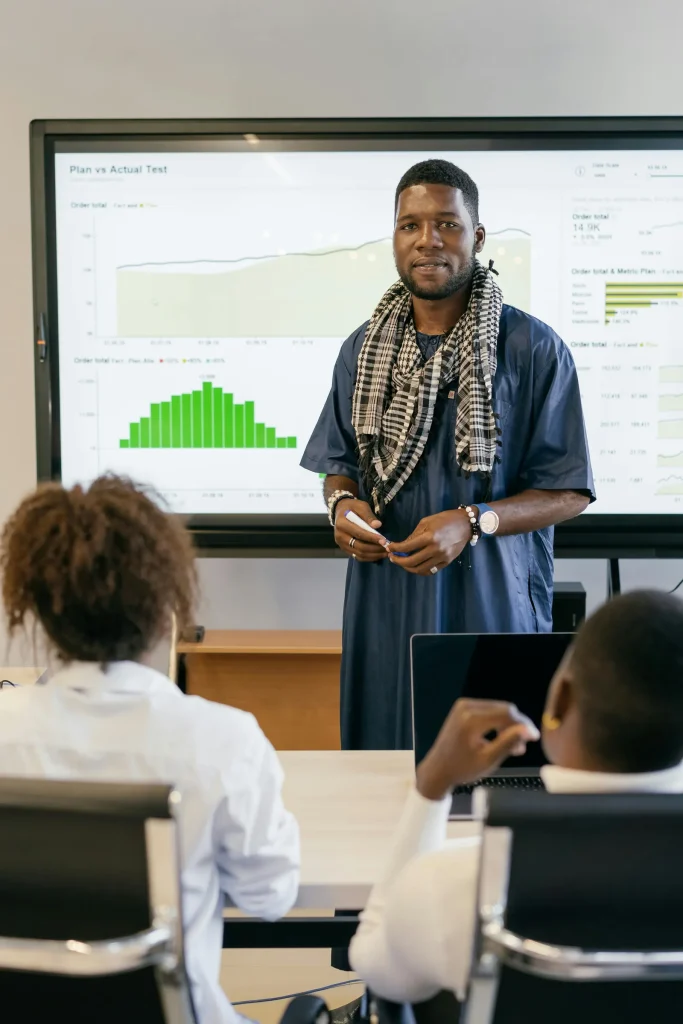 Security professional presenting AI-driven cybersecurity analytics dashboard to team in bright modern office representing how AI will change cybersecurity defense