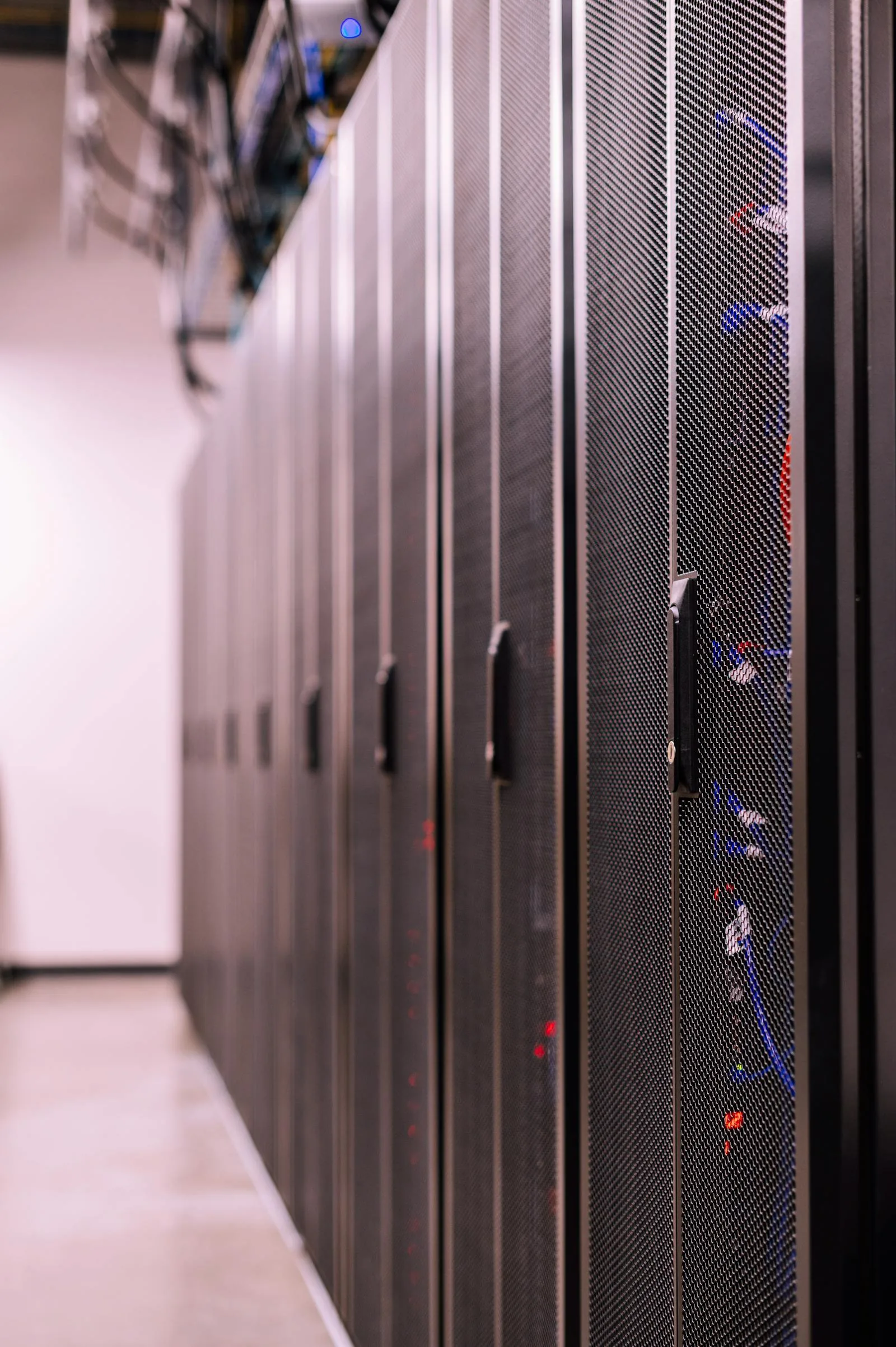 Row of server cabinets in data center representing network detection and response infrastructure monitored by AI behavioral analytics