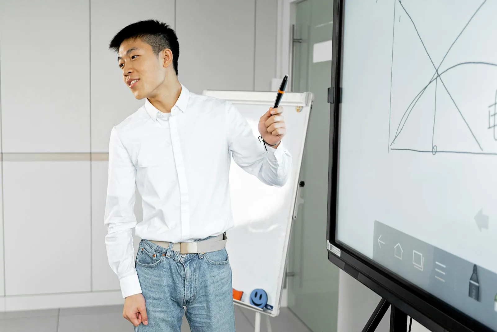 Young professional presenting with smart board and marker in modern office setting demonstrating presentation structure