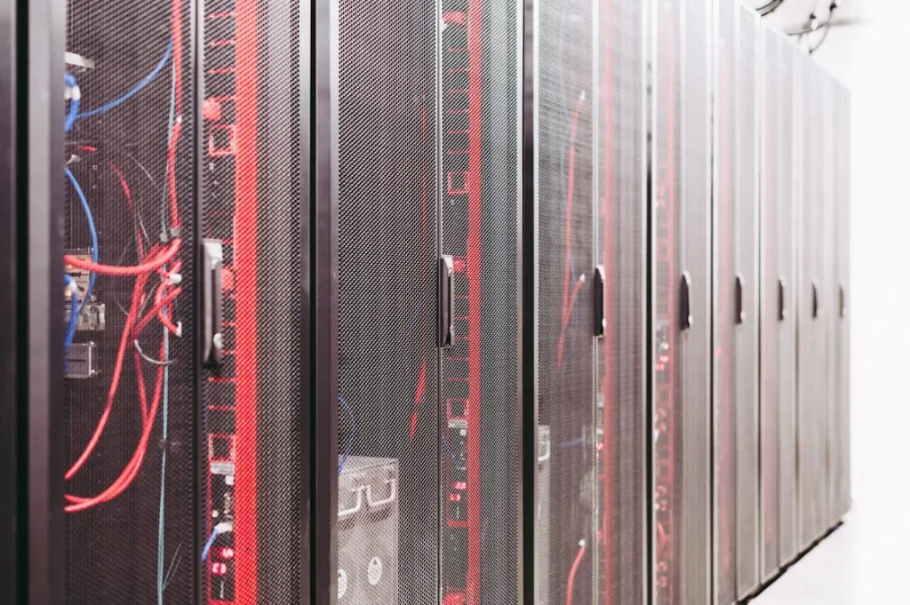 Server racks with network cables representing AI-powered information security infrastructure and identity management
