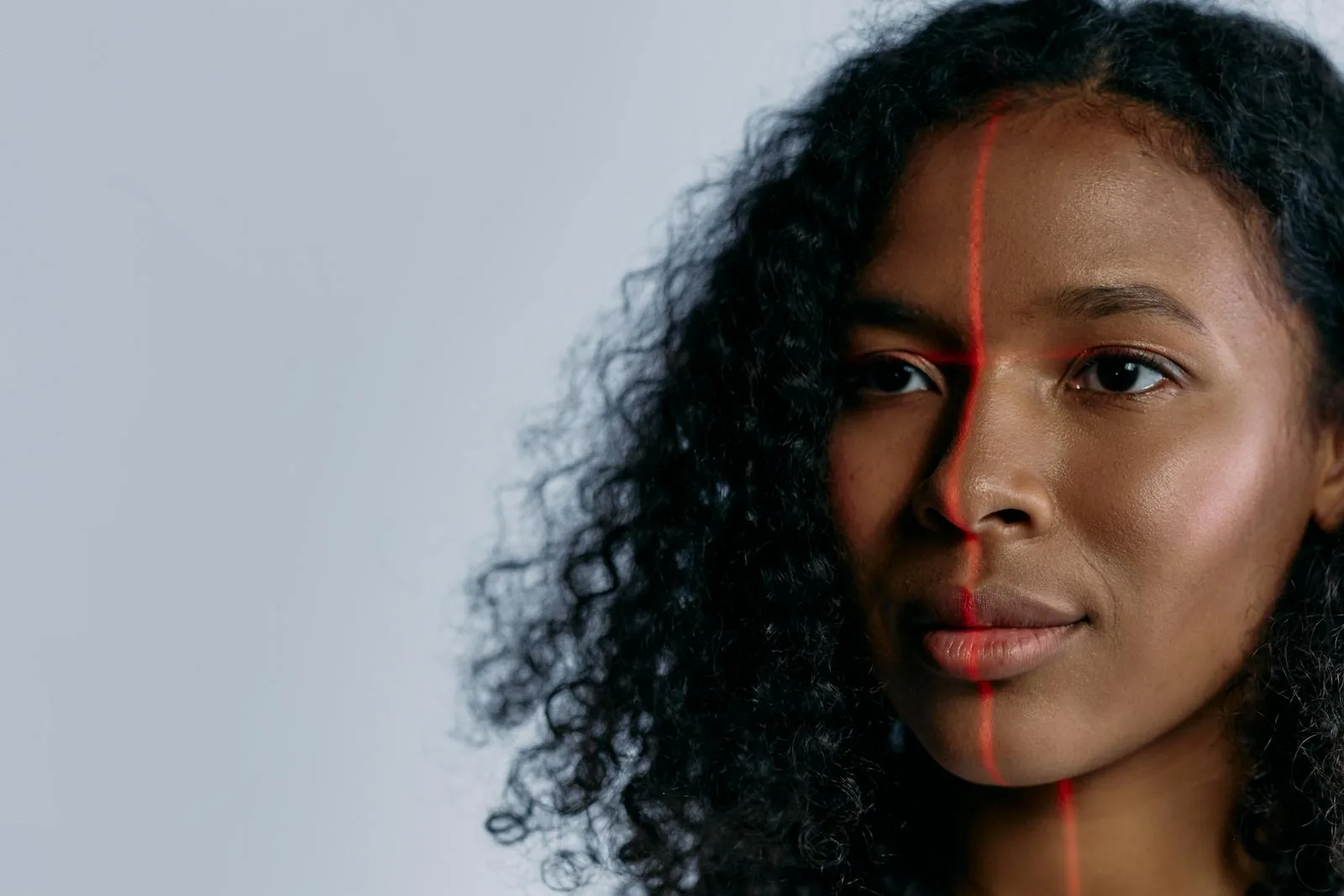 Woman with red laser scan line across face representing AI facial recognition technology accuracy and biometric surveillance
