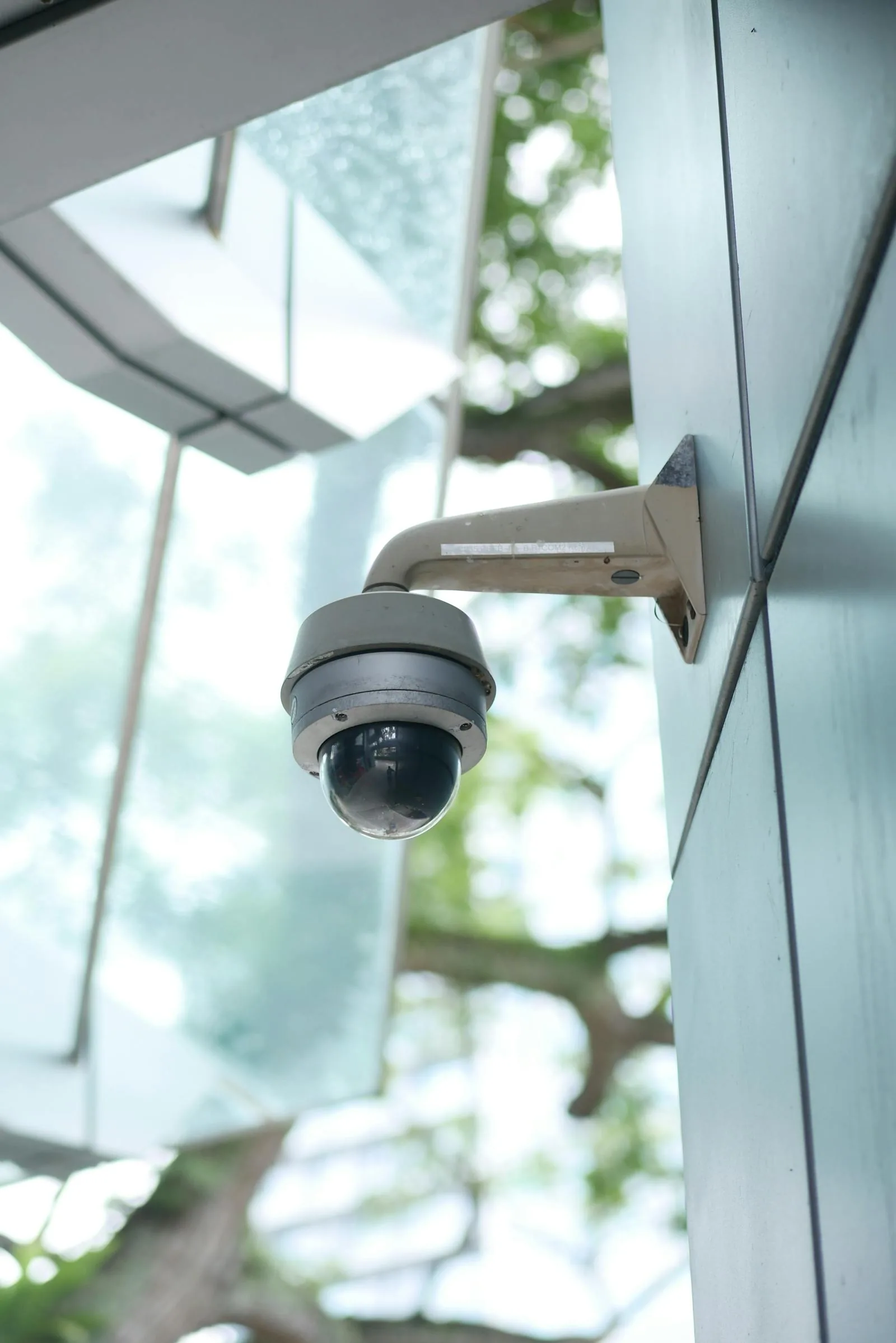 High-tech dome security camera mounted on modern building representing AI video analytics and smart surveillance technology