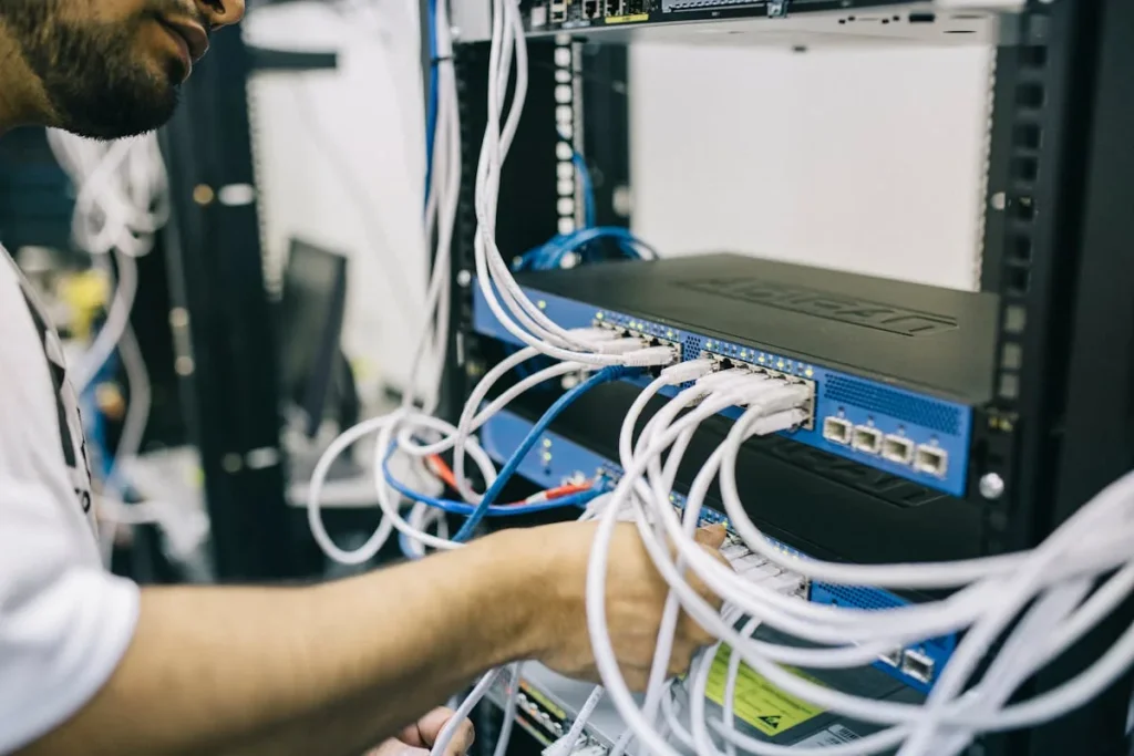 IT professional configuring network cables in server rack representing artificial intelligence network security