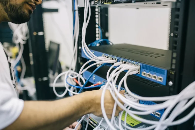 IT professional configuring network cables in server rack representing artificial intelligence network security