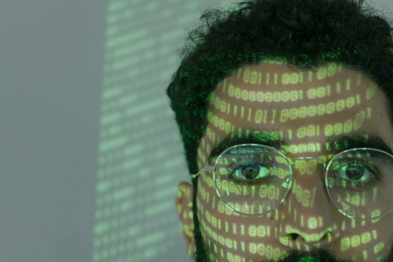 Man with binary code projected on face representing AI security threats including data poisoning and adversarial attacks