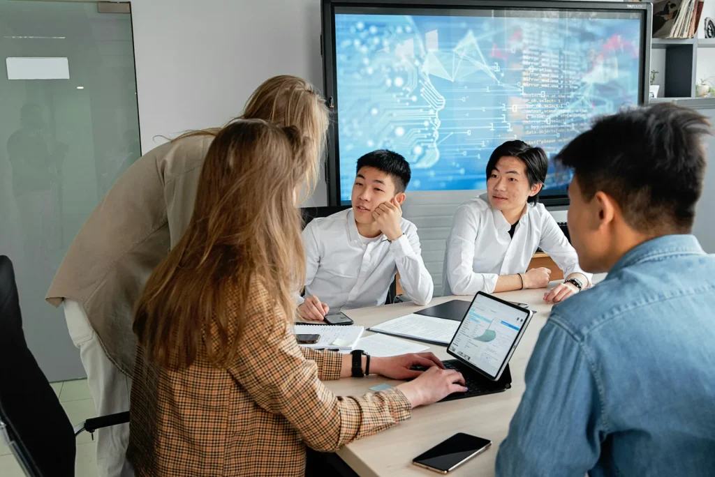 Diverse technology security team collaborating in meeting room with AI circuit board visualization on screen