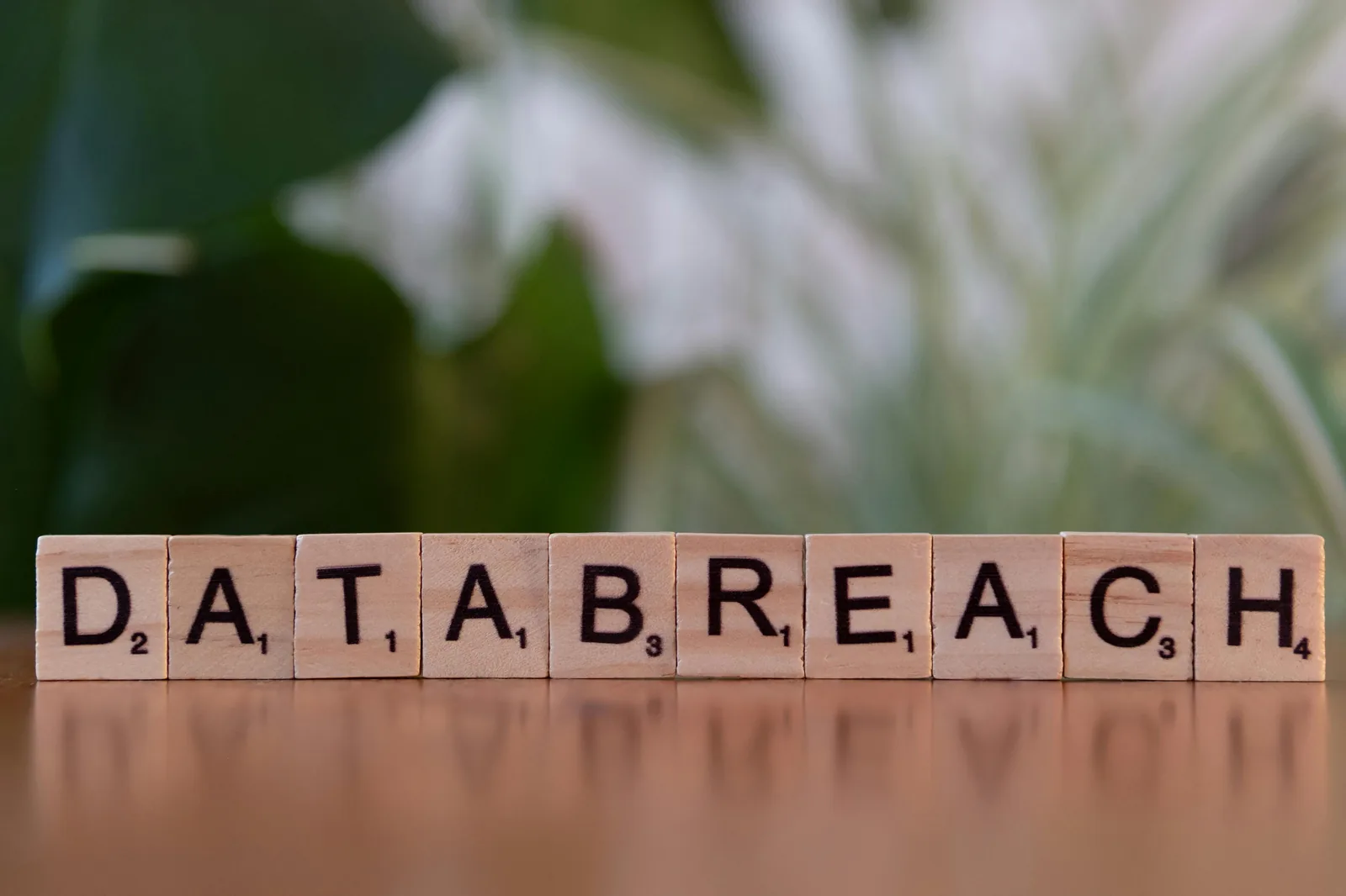 Scrabble tiles spelling DATA BREACH on wooden surface representing artificial intelligence system security risks and data poisoning