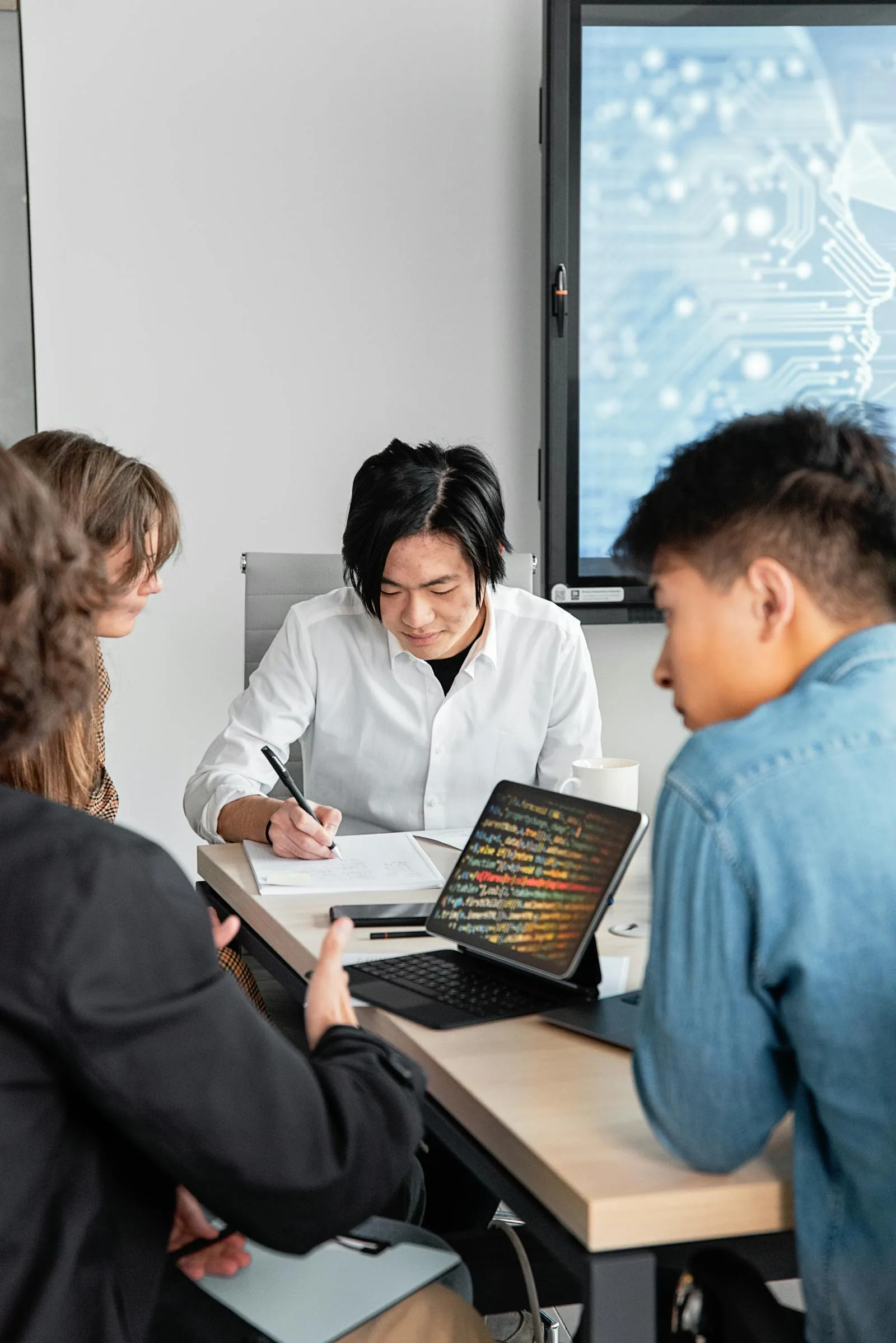 Security analysts reviewing code and threat intelligence on devices with digital circuit board display