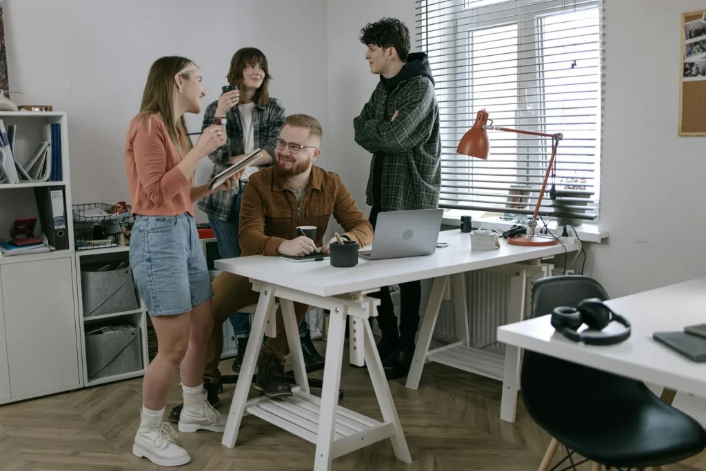 Small business team discussing security intelligence platform on laptop in bright startup office representing best security intelligence for businesses Microsoft Sentinel CrowdStrike SentinelOne MDR