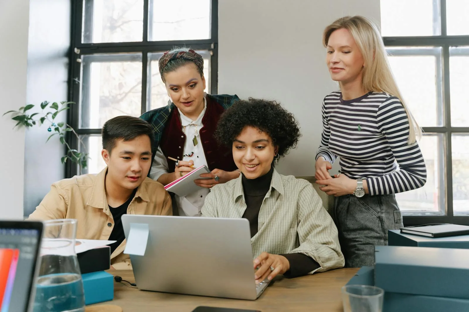 Small business security team reviewing threat intelligence platform on laptop in bright modern office representing best security intelligence for businesses Microsoft Sentinel CrowdStrike SentinelOne