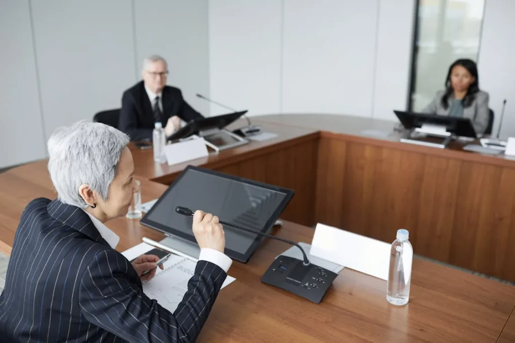 Senior executive team in formal boardroom discussing corporate security intelligence program