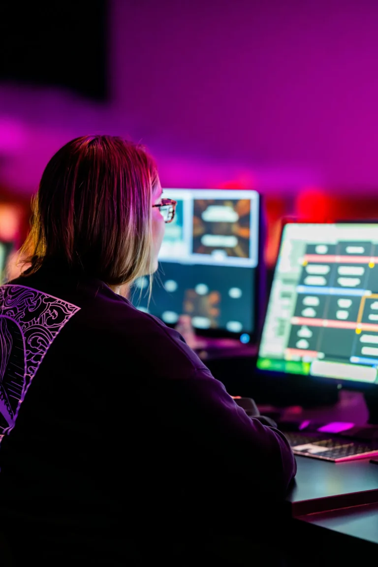 Cyber intelligence analyst reviewing threat data at multiple monitors