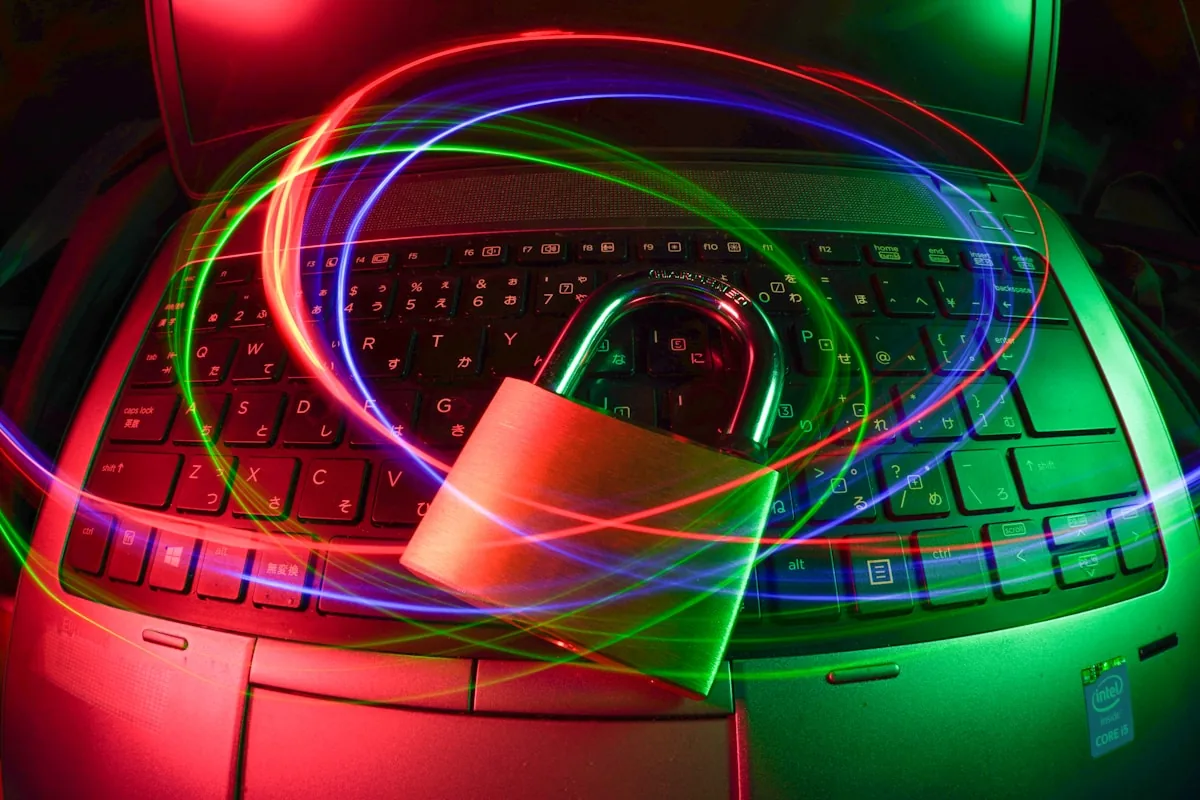 Open padlock on laptop keyboard with colorful light trails representing cyber intelligence and cyber security career opportunities