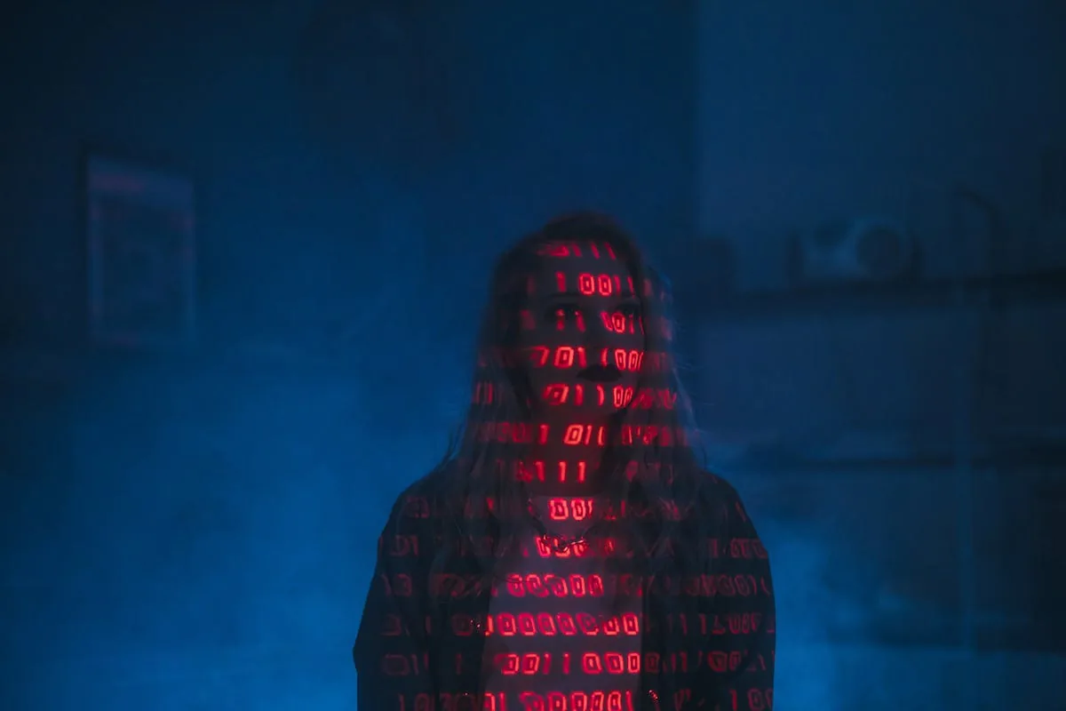 Silhouette with red binary code projected representing AI threat detection in cyber security