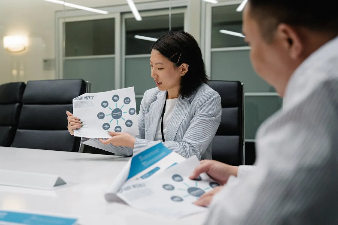 Executive security team briefing corporate leader on protection intelligence program in bright conference room representing executive security intelligence programs implementation best practices