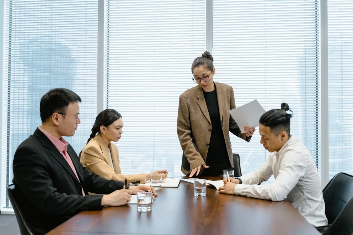 Corporate executive reviewing security intelligence briefing on tablet in bright private office representing executive security intelligence threat categories targeting detection