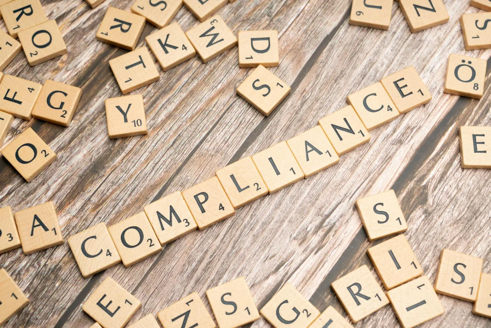 Scrabble tiles spelling COMPLIANCE representing AI-driven ISO 27001 information security compliance automation