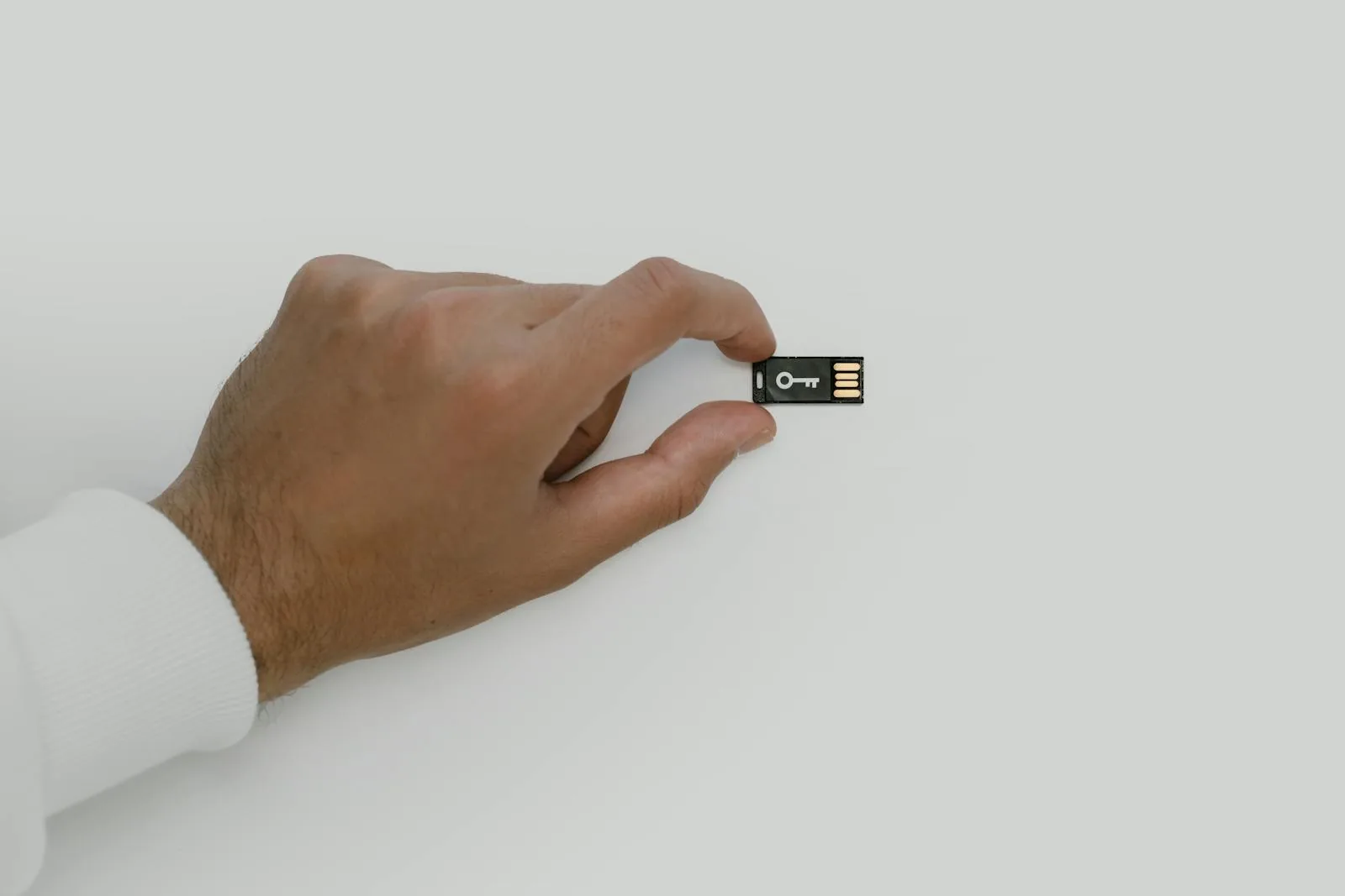 Hand holding USB security key representing AI-powered data classification in information security