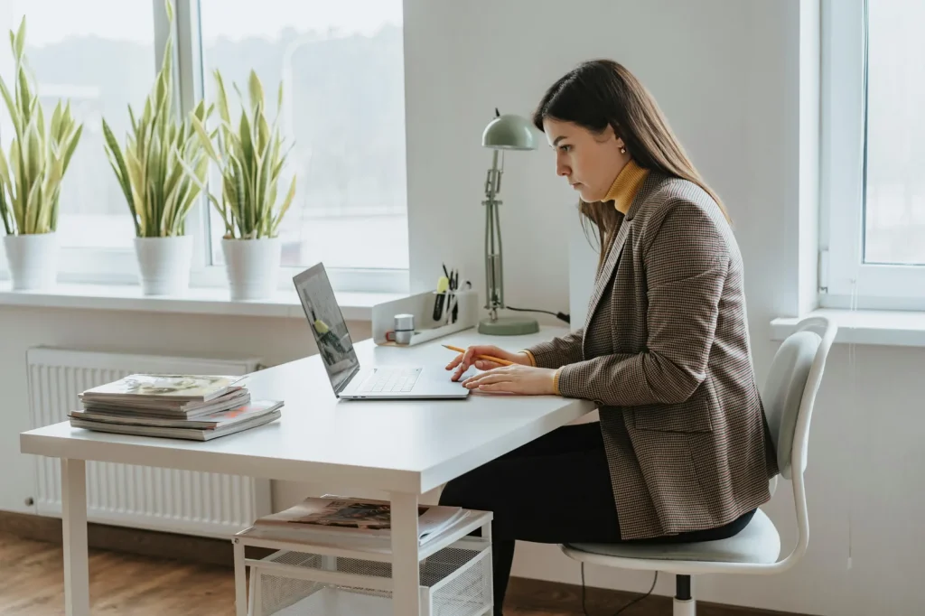 Professional analyst working at laptop in bright modern office representing intelligence and cyber security studies career professional