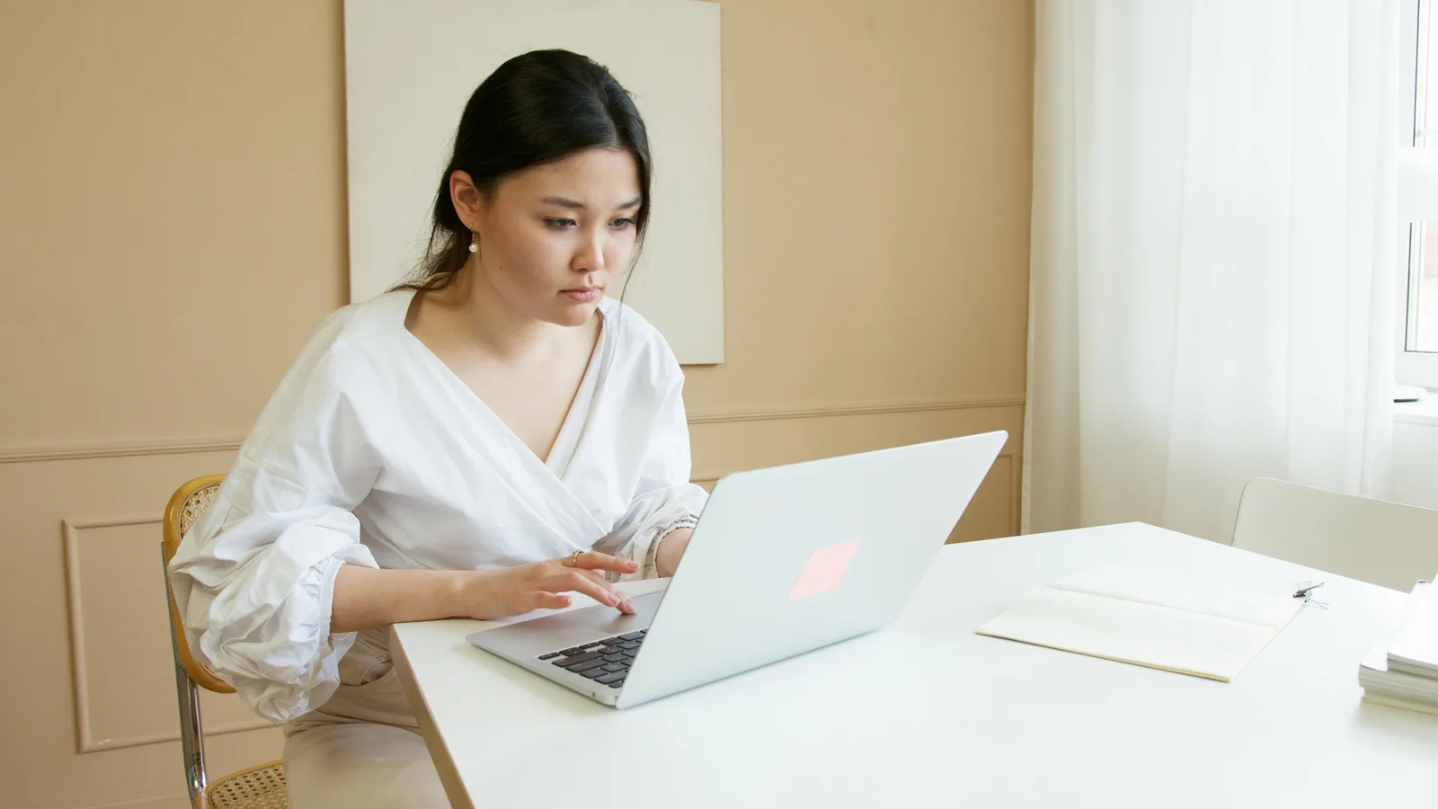 Security professional working at laptop in bright modern workspace representing intelligence cycle cyber security six phases direction collection processing analysis dissemination feedback