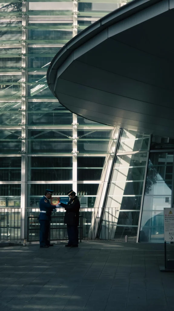 Professional security officers reviewing threat intelligence briefings at modern corporate facility