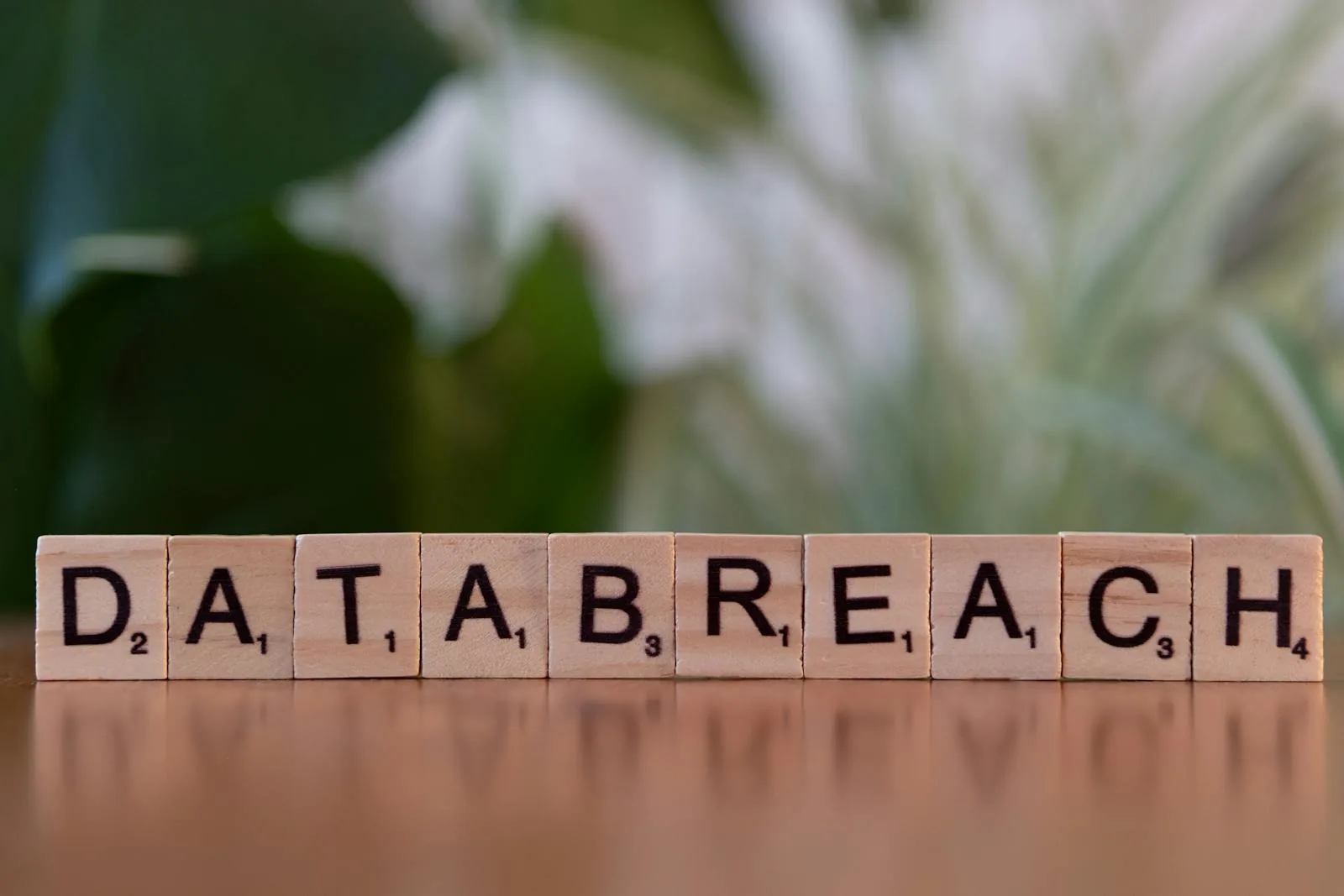 Scrabble tiles spelling DATA BREACH representing the attack vectors and vulnerabilities that compromise artificial intelligence systems