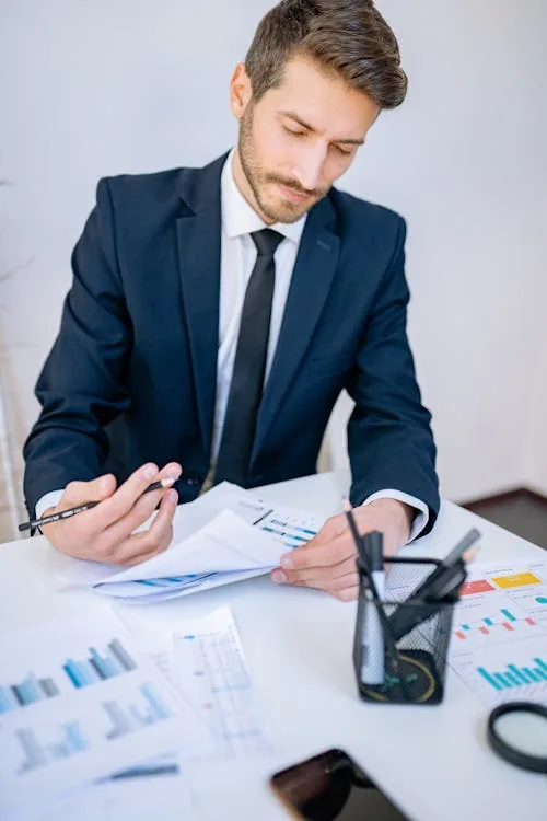 Security intelligence analyst reviewing threat reports at computer in bright modern office representing security intelligence analyst jobs responsibilities skills workflow