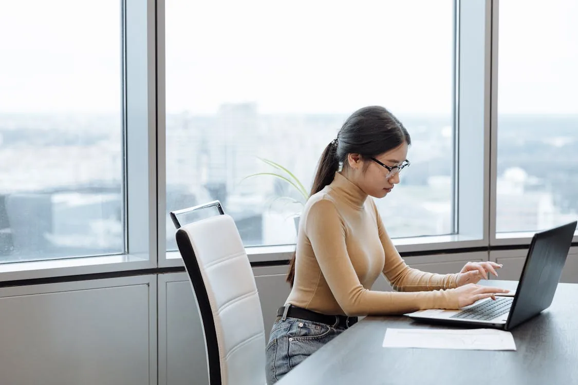 Security intelligence analyst reviewing threat data on multiple monitors in bright professional operations center representing security intelligence analyst role responsibilities skills