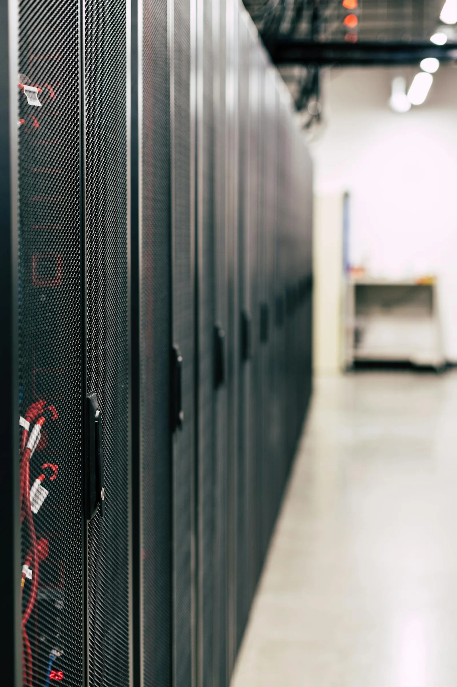 Long row of black enterprise server cabinets with red cable management in modern data center representing security intelligence data source infrastructure