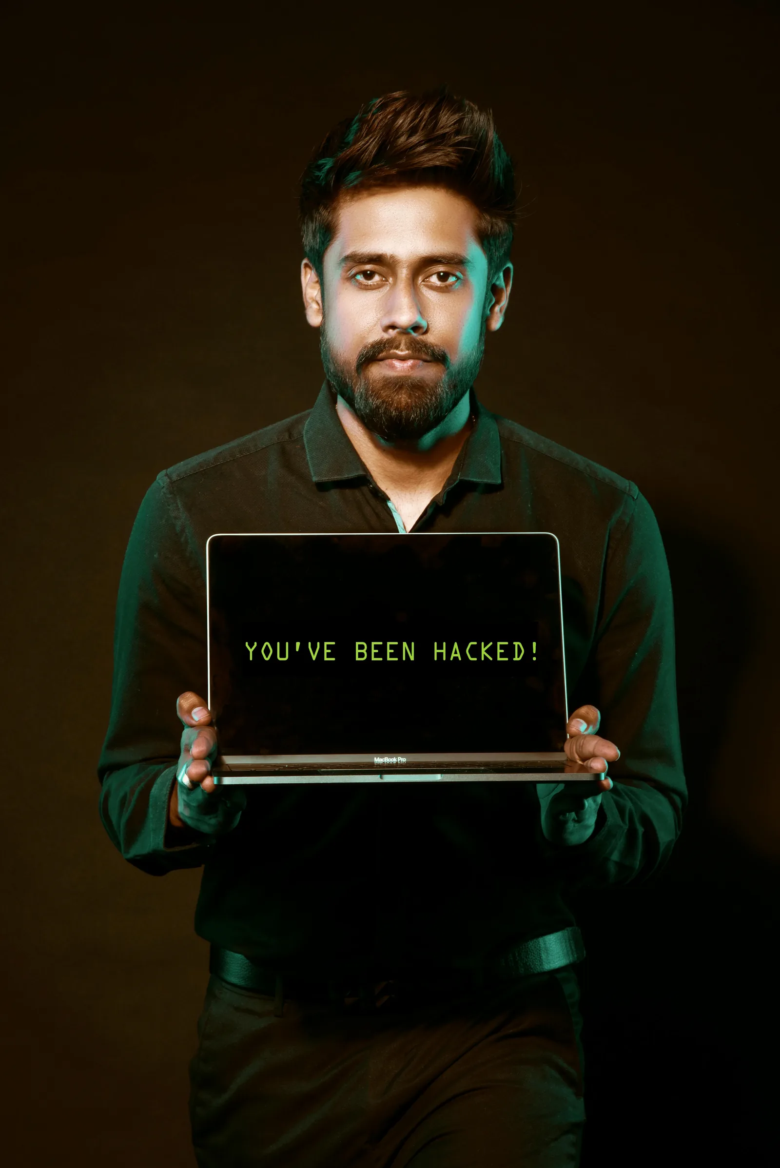 Hacker holding laptop showing how attackers exploit AI models through prompt injection and adversarial attacks