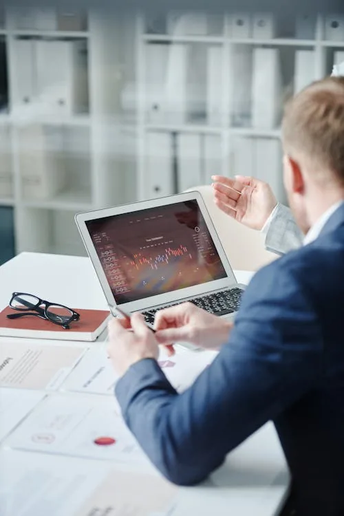 Enterprise security professional reviewing top security intelligence company data on laptop in bright office representing top companies offering security intelligence comparison