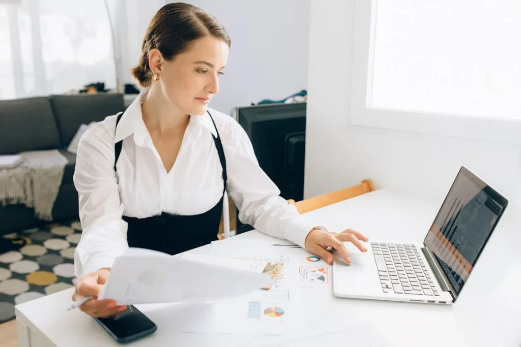 Business analyst reviewing top-rated security intelligence company evaluation data on laptop in bright office