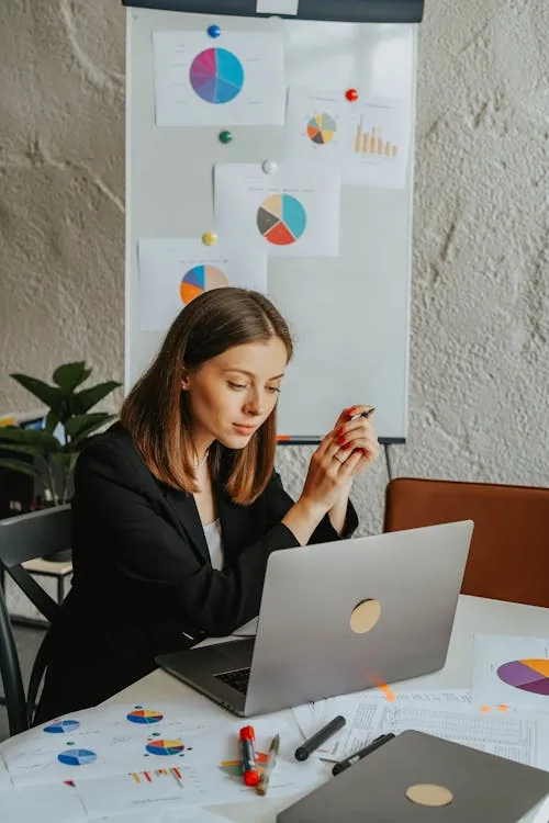 Enterprise analyst reviewing top-rated security intelligence company evaluation scores on laptop in bright professional office representing top rated security intelligence companies Gartner CrowdStrike Recorded Future